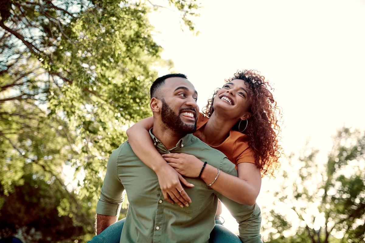 A happy couple lifting each other up outdoors