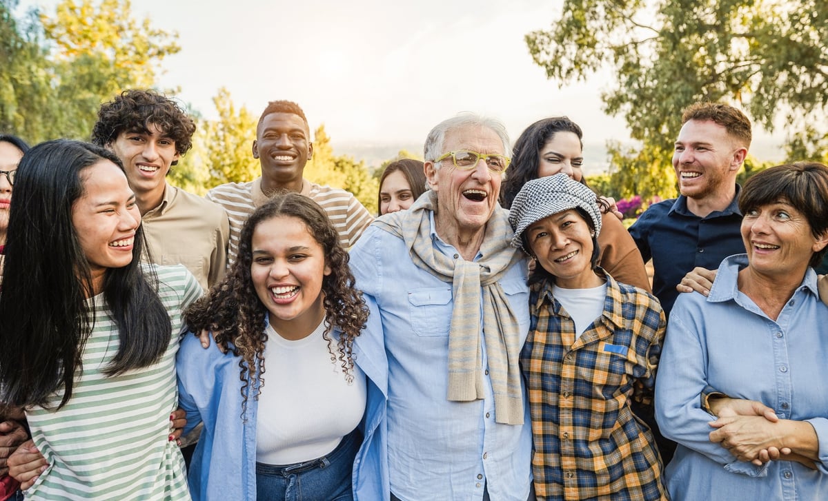 A multigenerational, multiracial group of friends smiling together