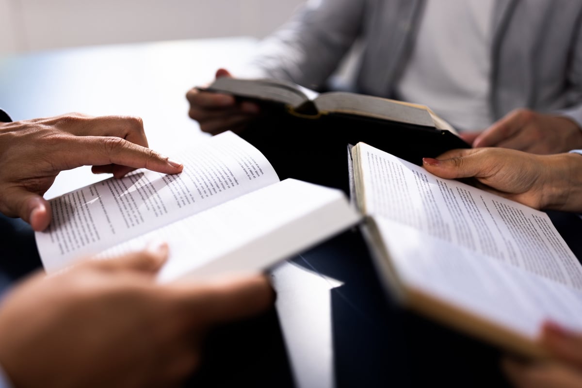 A diverse group of men studying the Bible and praying together