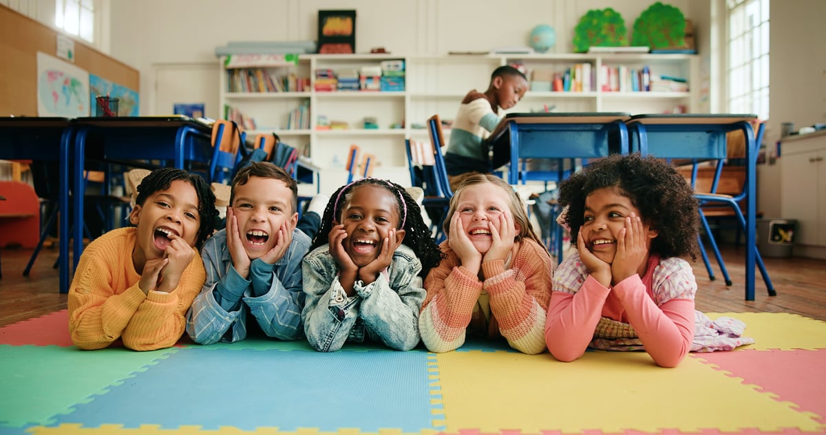 A diverse group of children smiling together in class