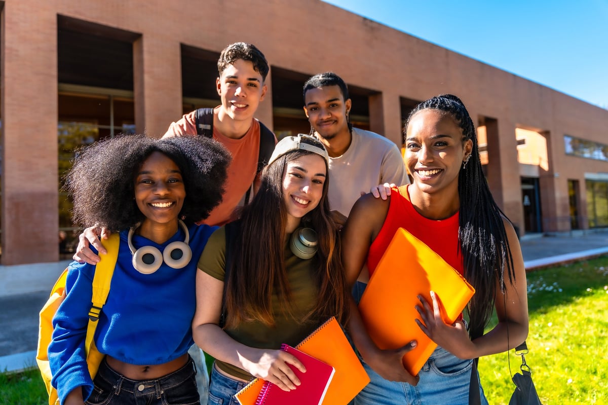 A diverse group of students standing together with books