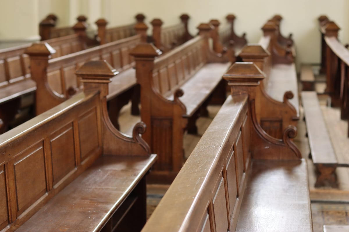 Rows of traditional wooden church pews where our church family gathers